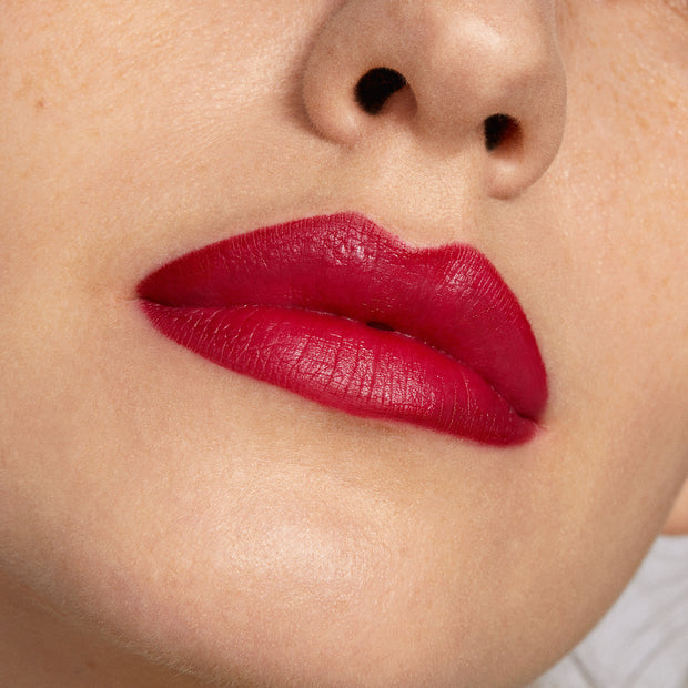 Bold lips wearing Bichette ColourPop Lippie Pencil, a rich cherry red liner filling and defining the mouth with a smooth matte finish; tight close-up highlights crisp edges and saturated pigment on fair skin.