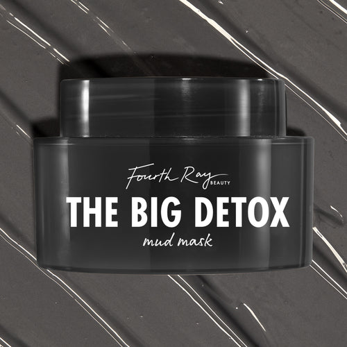 Black Fourth Ray Beauty The Big Detox Mud Mask jar displayed in a close-up flat lay, the ColourPop Face Mask resting on swirled charcoal mud with white streaks, showcasing the sleek container and bold white logo for detoxifying skincare.