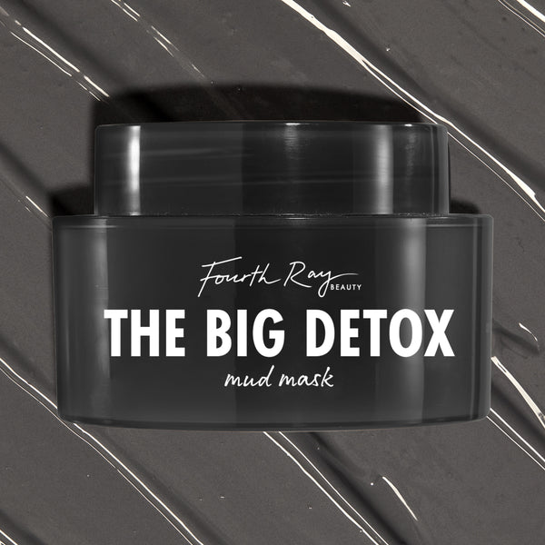 Black Fourth Ray Beauty The Big Detox Mud Mask jar displayed in a close-up flat lay, the ColourPop Face Mask resting on swirled charcoal mud with white streaks, showcasing the sleek container and bold white logo for detoxifying skincare.