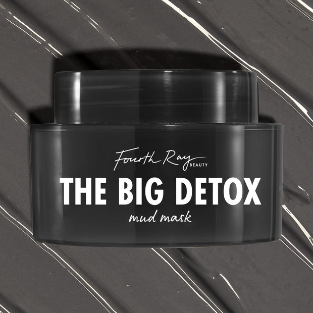 Black Fourth Ray Beauty The Big Detox Mud Mask jar displayed in a close-up flat lay, the ColourPop Face Mask resting on swirled charcoal mud with white streaks, showcasing the sleek container and bold white logo for detoxifying skincare.