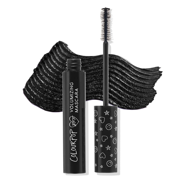 ColourPop BFF Mascara Black on Black displayed open, wand upright showing dense bristle brush, with a bold black swatch behind; sleek black tube reads Volumizing Mascara and cap features white heart, star, and smiley icons.