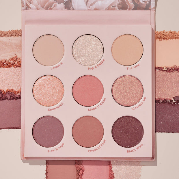 Blushing Nude ColourPop Shadow Palette Set showcases nine rosy neutral eyeshadows - matte, shimmer, and metallic - in a pink compact with shade names like Pop a Bottle and Blush Wine, shown over coordinating swatches for color payoff.