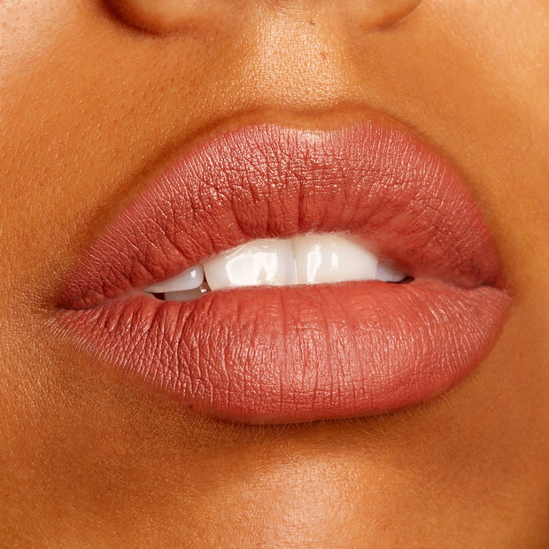 Lips wear Brink, a ColourPop Lippie Pencil, defining and filling the mouth in a warm rosy terracotta nude with a soft matte finish, shown in a close-up beauty swatch to highlight the creamy, long-wearing precision of this lip liner.