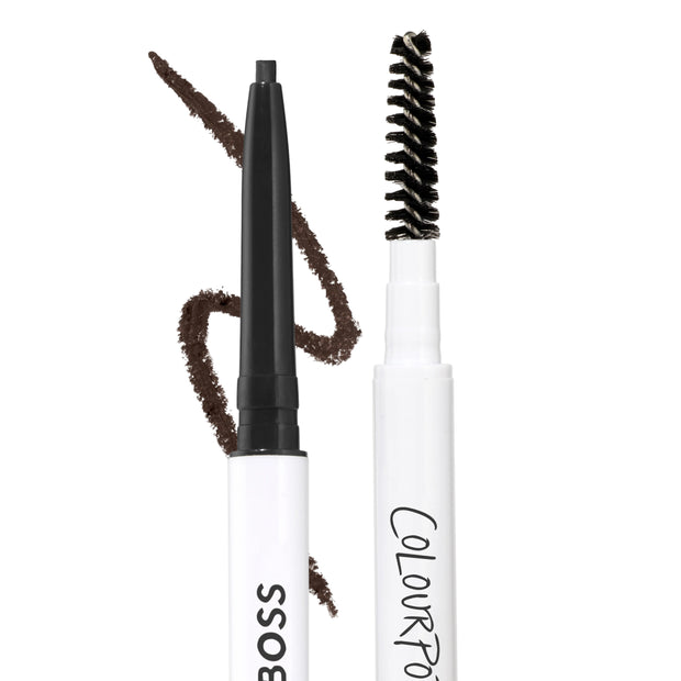 Soft Black Brow Boss Pencil shown uncapped with a fine retractable brow tip and spoolie brush on a white background, with a dark brown swatch stroke demonstrating precise brow makeup color payoff.