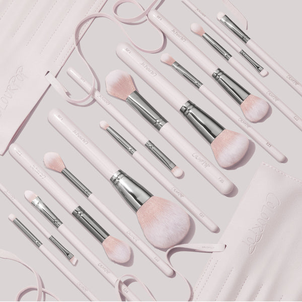 Stone Cold ColourPop Makeup Brush Kit showcasing soft pink powder, blush, and eye brushes with silver ferrules, laid out in a flat lay beside a matching roll-up brush case on a pale backdrop.