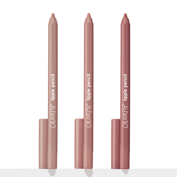 Three ColourPop Lippie Pencil liners from the Cool Besties set stand upright with caps at the base, tips exposed in light beige nude, soft pink nude, and rosy mauve shades against a white studio background.