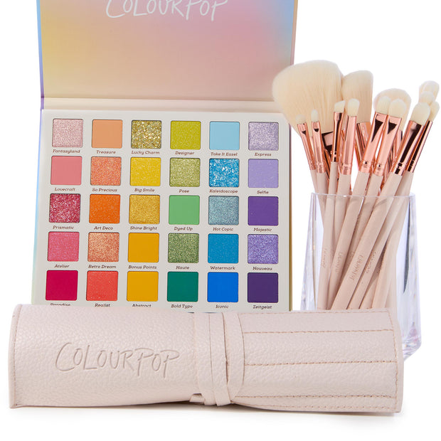 Sweet Fantasy ColourPop Shadow Palette & Brush Set showcasing an open 30‑pan rainbow eyeshadow palette with matte, shimmer, and glitter shades, paired with cream-handled brushes with rose-gold ferrules in a clear cup, plus a blush-pink ColourPop brush roll.