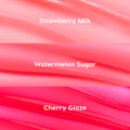 Fruit Basket ColourPop Glossy Lip Balm Trio swatches display three glossy shades - Strawberry Milk (soft baby pink), Watermelon Sugar (juicy coral), and Cherry Glaze (vivid hot pink) - shown as smooth, lacquered stripes in a close-up texture.