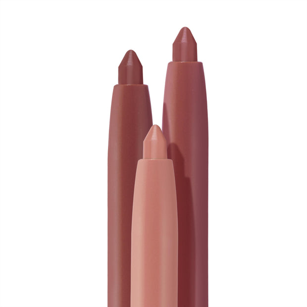 Three crayon-style lip liners stand upright with pointed tips in nude, pink, and mauve, showcasing the Lips Don’t Lie ColourPop So Juicy Plumping Lip Liner Set for precise lip lining on a clean white background.