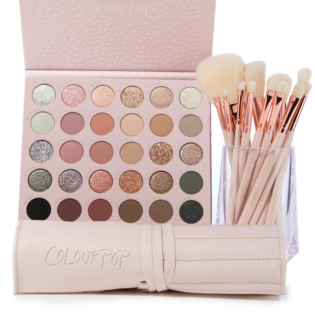 Major Eye Candy showcases a large neutral‑pink eyeshadow palette of mattes and glitters with rose‑gold brush set; brushes stand in a clear cup next to a blush‑pink ColourPop brush roll, highlighting the ColourPop Shadow Palette & Brush Set.