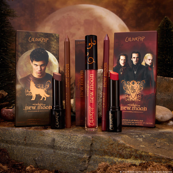 ColourPop Lip Set Pack Member showcases deep brown and berry-red lipsticks with matching lip pencils and red gloss, standing on stone with a forest and full moon backdrop, in Twilight: New Moon–themed packaging.