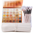 Metallic Mood ColourPop Shadow Palette & Brush Set showcasing a 30-pan warm-to-cool mix of matte and metallic neutrals - golds, coppers, silvers - with soft pink-handle brushes in a clear cup beside a cream ColourPop brush roll on a white background.