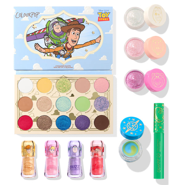Toy Story and ColourPop Collection Full Collection Set arranged flat lay: 15-shade eyeshadow palette with Woody and Buzz cover art, three glitter pots, four character lip glosses, a blue-green swirled eye gel, and a green mascara on white - ColourPop Full Collection Set.