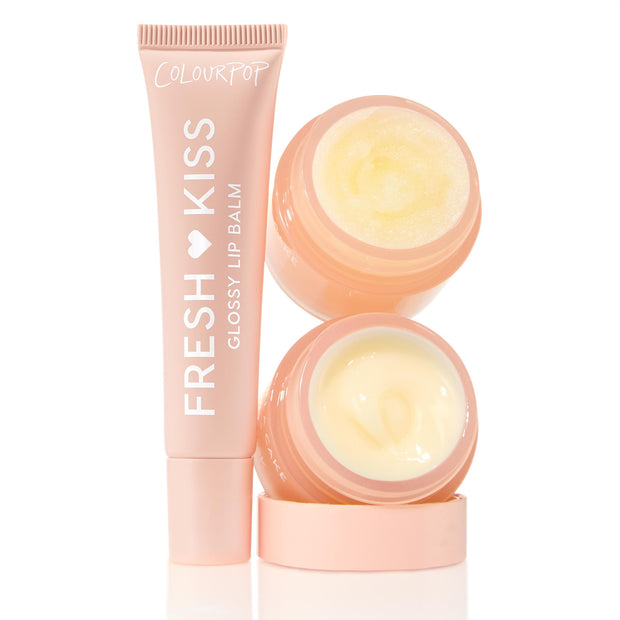 ColourPop Lip Care Kit Vanilla Dream features a Fresh Kiss Glossy Lip Balm tube standing beside two open peach jars - one grainy lip scrub and one creamy balm - revealing pale yellow formulas on a clean white background.