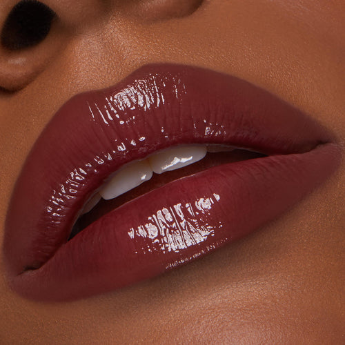 Glossy deep-berry lips wearing Juicy Berry, the ColourPop So Juicy Plumping Lip Liner & Balm Set defining the lip line while the balm delivers high-shine, plumped finish; close-up of a slightly parted mouth with teeth visible.