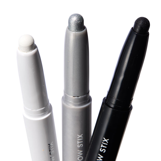 Totally Wicked ColourPop Shadow Stix trio showing exposed tips - matte white, metallic silver, and black shimmer - standing upright in white, gray, and black twist-up tubes on a bright white background.