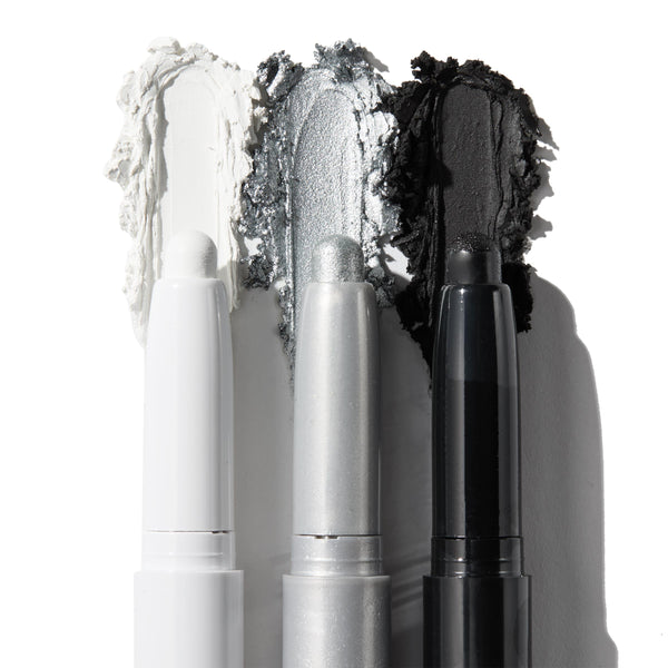 ColourPop Shadow Stix Totally Wicked trio shows uncapped pencils with rich swatches - matte white, metallic silver, and matte black - smeared behind each tip on a white background for bold smoky or graphic eye looks.