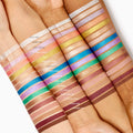 Quokka Shadow Stix swatch swept in a single stripe on multiple skin tones, displayed among the full lineup of ColourPop Shadow Stix to show creamy, blendable eyeshadow-stick payoff and finish.