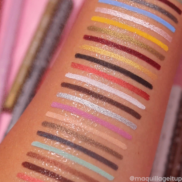 ColourPop Crème Gel Liner The Total Package swatches stripe a forearm, water beading on top to show smudge-resistant wear; a spectrum of mattes and shimmers - mint, lilac, gold, red, black - displayed against a pink backdrop.