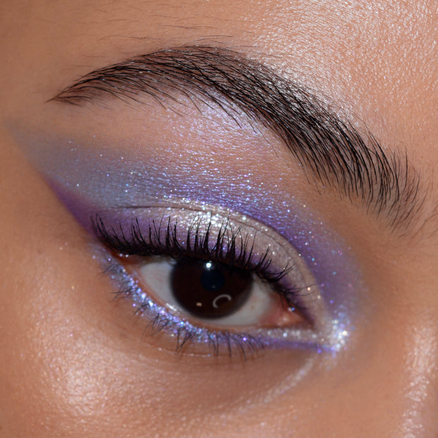 Shimmery lavender-to-violet winged eye makeup with icy inner-corner highlight and sparkle along the lower lash line, created using the All Amethyst Shadow Palette, a ColourPop Shadow Palette; close-up of one eye and brow.