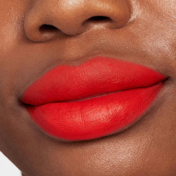 Bold matte orange-red lips showcase Chi Chi Lippie Stix in full coverage, highlighting a smooth, velvety finish on deep skin in a tight beauty close-up, perfect to pair with a ColourPop Lippie Pencil for crisp, defined edges.