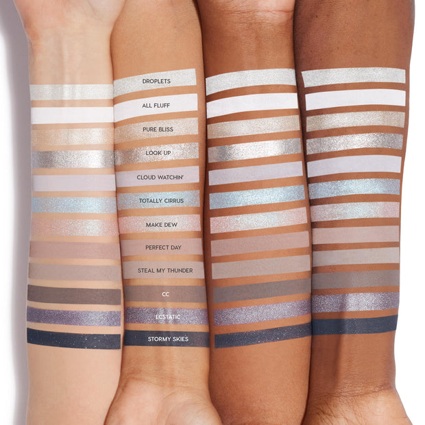 Cloud 9 ColourPop Shadow Palette swatches line three skin tones, showcasing 12 cool-toned mattes and shimmers - from crisp ivory and taupe to icy blue, silver, lilac, and deep navy - each shade labeled (Droplets to Stormy Skies) for easy comparison.