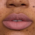 Close-up of a model’s lips wearing Floating on Air Cloud Whip Blurring Liquid Lipstick, showing a soft matte pink-nude shade with smooth, cloud-like texture on freckled skin, highlighting the lightweight Cloud Whip finish.