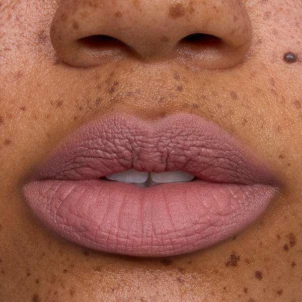 Close-up of a model’s lips wearing Floating on Air Cloud Whip Blurring Liquid Lipstick, showing a soft matte pink-nude shade with smooth, cloud-like texture on freckled skin, highlighting the lightweight Cloud Whip finish.