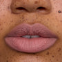 Close-up of a model’s lips wearing Floating on Air Cloud Whip Blurring Liquid Lipstick, showing a soft matte pink-nude shade with smooth, cloud-like texture on freckled skin, highlighting the lightweight Cloud Whip finish.