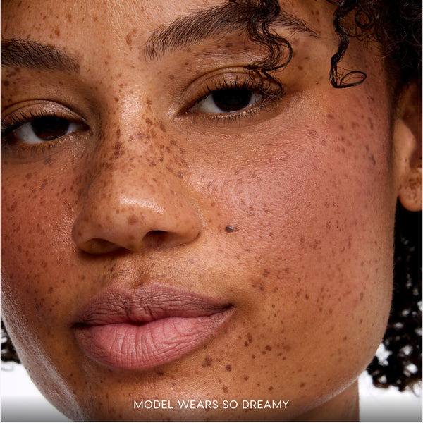 Close-up of a model’s face wearing the Cloud Crushin lip trio from the Value Sets collection, showing soft blurred nude-pink liquid lipstick on natural lips with minimal makeup to highlight the hydrating, diffused finish.