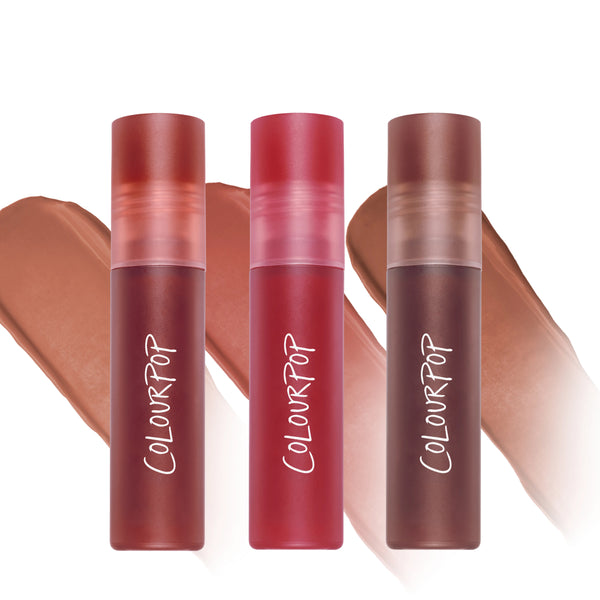 ColourPop Heavenly Nudes lip trio standing upright with three matte liquid lipstick tubes in warm nude and rosy tones, swatched behind each shade, promoted as a makeup value set for versatile everyday lip looks.