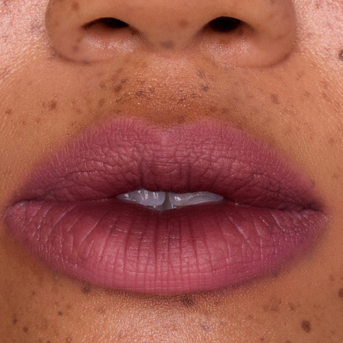 Full, close-up lips wearing Mocha Plum Lip Ombre Duo, showing a soft matte plum gradient with subtle blurring effect on freckled skin, highlighting the rich color payoff of this CloudWhip lipstick from the Mocha Plum Value Sets collection.