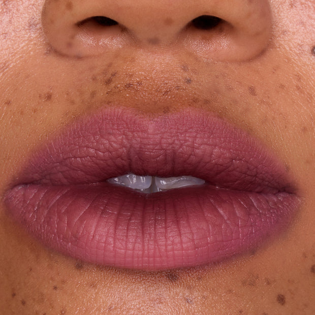 Full, close-up lips wearing Mocha Plum Lip Ombre Duo, showing a soft matte plum gradient with subtle blurring effect on freckled skin, highlighting the rich color payoff of this CloudWhip lipstick from the Mocha Plum Value Sets collection.