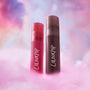 ColourPop Mocha Plum Lip Ombre Duo value set with two frosted liquid lip tubes, one rosy pink and one deep plum, standing upright in fluffy pink clouds against a dreamy pastel sky background.