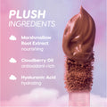 Petal Plush Lip Trio doe-foot applicator swirls whipped nude-pink liquid lipstick against a dreamy pink and purple cloud background, highlighting plush ingredients—marshmallow root extract, cloudberry oil, and hyaluronic acid—for hydrating value sets shoppers.