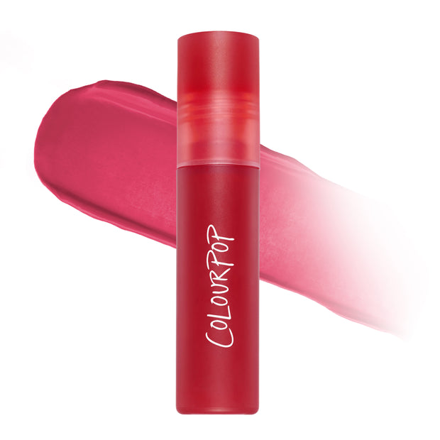 ColourPop Mile High Cloud Whip Blurring Liquid Lipstick standing upright with a blurred swatch of vibrant rosy-red color behind it on a white background, highlighting the soft-matte Cloud Whip finish for lips.