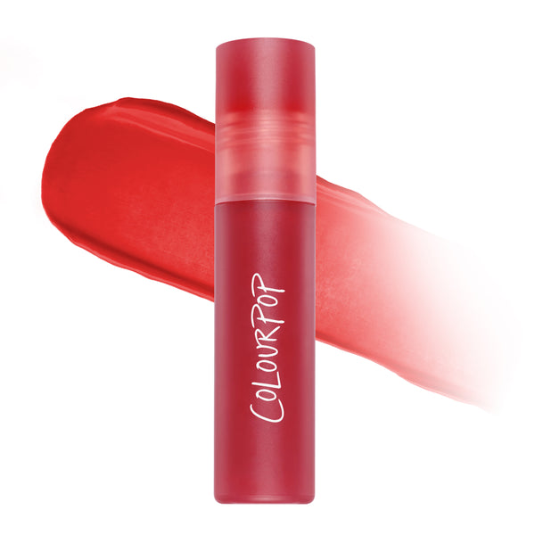 ColourPop Sky’s the Limit Cloud Whip Blurring Liquid Lipstick standing upright in a frosted red tube, shown over a soft-focus swatch of vibrant red Cloud Whip formula on a clean white background for US makeup shoppers.