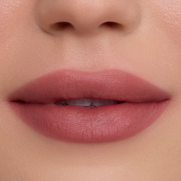 Close-up of smooth, full lips wearing So Dreamy Cloud Whip Blurring Liquid Lipstick in a soft rosy nude shade, showing velvety blurred edges and satin-matte finish against flawless, natural skin.