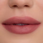 Close-up of smooth, full lips wearing So Dreamy Cloud Whip Blurring Liquid Lipstick in a soft rosy nude shade, showing velvety blurred edges and satin-matte finish against flawless, natural skin.