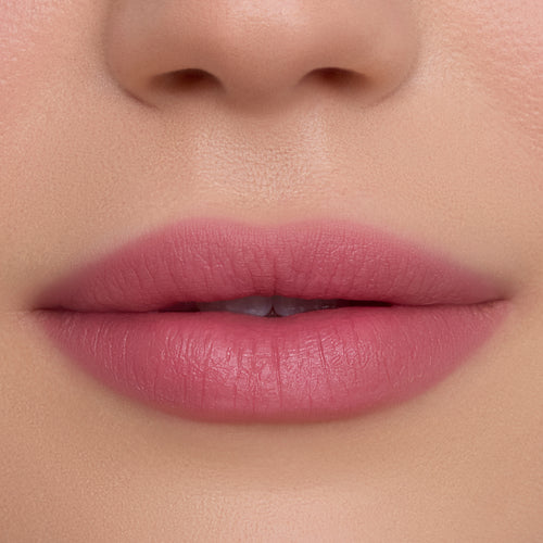 Close-up of smooth, full lips wearing What the Fluff Cloud Whip Blurring Liquid Lipstick in a soft matte pink shade, showing even, blurred edges and velvety texture against flawless natural skin.
