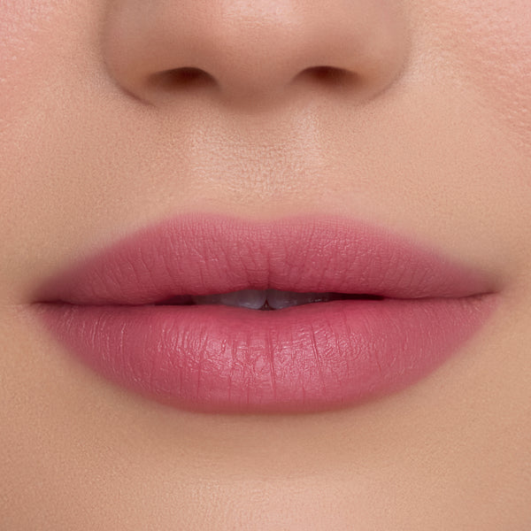 Close-up of smooth, full lips wearing What the Fluff Cloud Whip Blurring Liquid Lipstick in a soft matte pink shade, showing even, blurred edges and velvety texture against flawless natural skin.