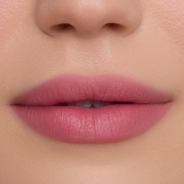 Close-up of smooth, full lips wearing What the Fluff Cloud Whip Blurring Liquid Lipstick in a soft matte pink shade, showing even, blurred edges and velvety texture against flawless natural skin.