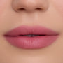 Close-up of smooth, full lips wearing What the Fluff Cloud Whip Blurring Liquid Lipstick in a soft matte pink shade, showing even, blurred edges and velvety texture against flawless natural skin.