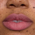 Close-up of freckled lips wearing What the Fluff Cloud Whip Blurring Liquid Lipstick in a soft matte pink shade, showing smooth, blurred edges and velvety Cloud Whip finish for an airy, lightweight lip look.