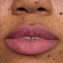Close-up of freckled lips wearing What the Fluff Cloud Whip Blurring Liquid Lipstick in a soft matte pink shade, showing smooth, blurred edges and velvety Cloud Whip finish for an airy, lightweight lip look.