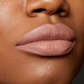 Lips wearing Beeper, a muted mauve nude, outlined and filled with the ColourPop Lippie Pencil for a smooth matte finish; extreme close-up beauty swatch on medium-brown skin highlighting crisp liner edges and velvety texture.