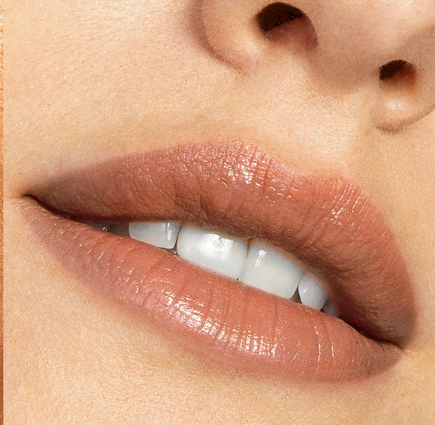 Softly parted lips wearing Cookie, a warm nude ColourPop Lippie Stix, showing creamy satin coverage and subtle shine in a tight beauty close-up.