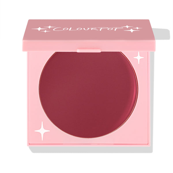 ColourPop Coyote cream blush compact sits half-open, revealing a deep berry pan in a pink square case with white star accents and ColourPop logo; matte cream formula for cheeks; ColourPop Cream Blush on a white background.