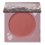 ColourPop Cream Blush A-Lister compact displaying a warm rosy-mauve pan, lid half-closed with bokeh print, set in lavender packaging with heart doodles and gold A-LISTER text, studio-lit on a white background.