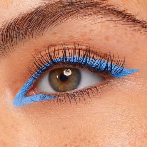 Prance ColourPop Crème Gel Liner tracing a vivid sky-blue graphic wing along the upper and lower lash lines, creating a sharp cat-eye on a close-up eye with long lashes.